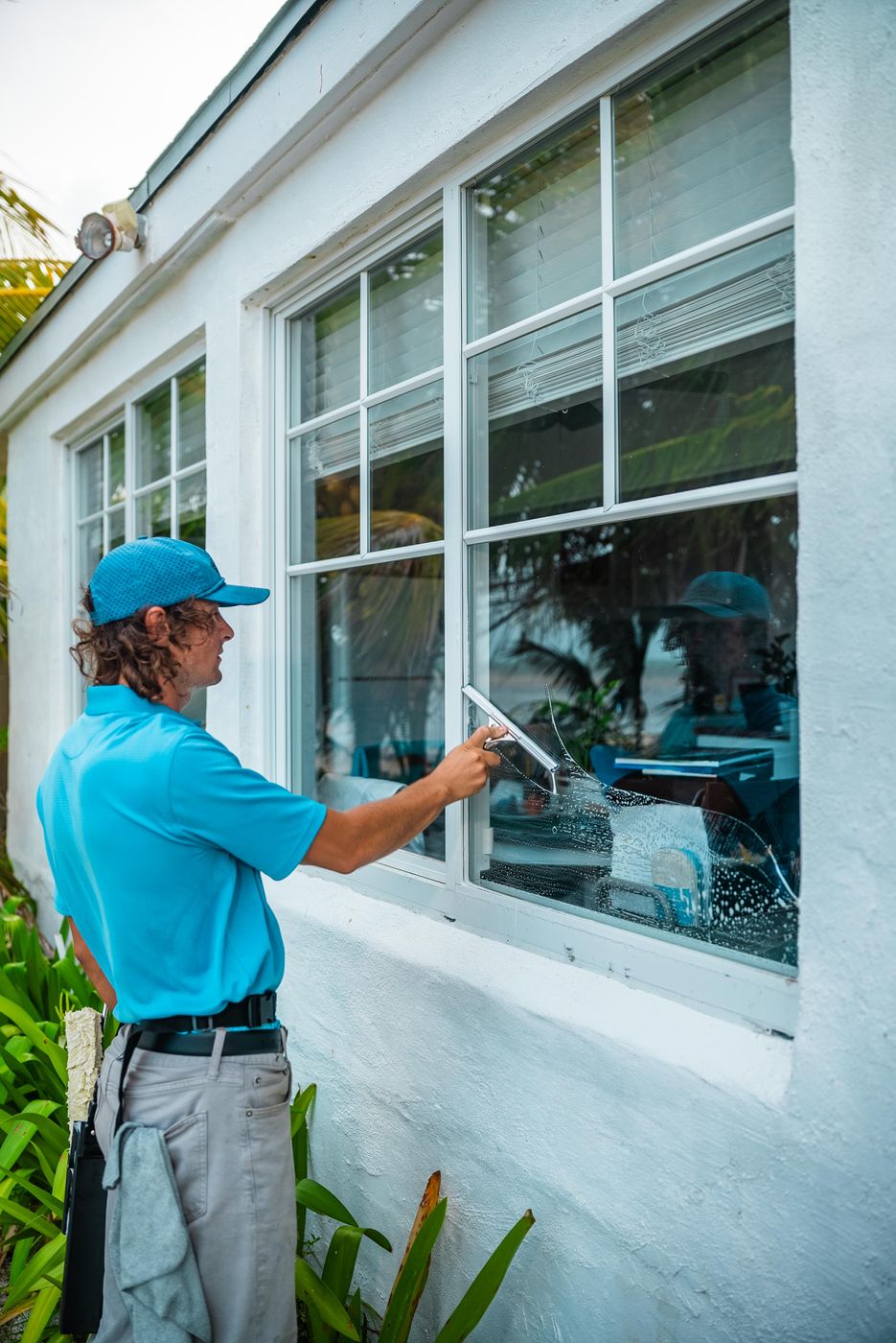 Sea Clear technician detailing an exterior window by hand at a Florida Keys home
